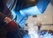 Man providing onsite welding services with a MIG welding gun to repair an item | Elite Welding & Fabrication
