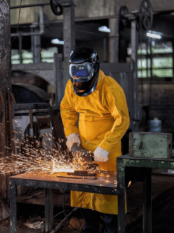 A man performs contract manufacturing services in a metal shop.