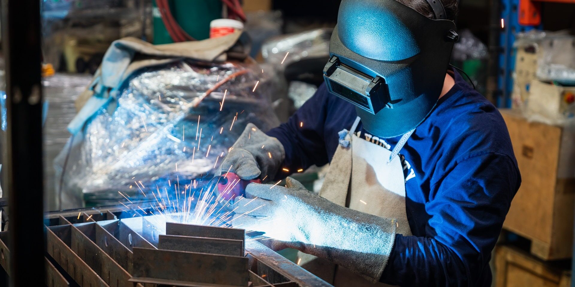 mechanic-worker-man-with-protect-mask-and-gloves-s-2023-11-27-04-55-20-utc-min A welding technician performs TIG welding on a piece of metal for a metalworking project.