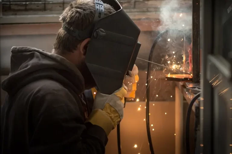 a-man-with-a-welding-machine-welds-a-metal-structu-2023-11-27-05-22-16-utc-min A young man with a welding mask and tool performs welding repairs on a metal structure.