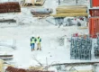 Building inspectors reading a blueprint on a construction site.