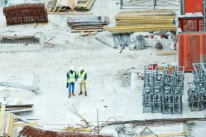Building inspectors reading a blueprint on a construction site.