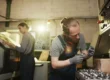 A man and woman produce small metal component parts in a metal manufacturing plant.
