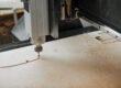 Close up of CNC engraving machine cutting wood in automated production workshop with sawdust flakes in air, copy space